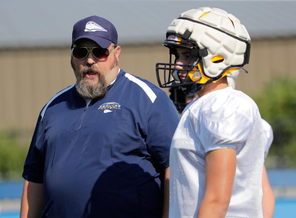 St. Mary Catholic head coach Josh Young talks with running back Ashton Post during practice Tuesday in Fox Crossing.