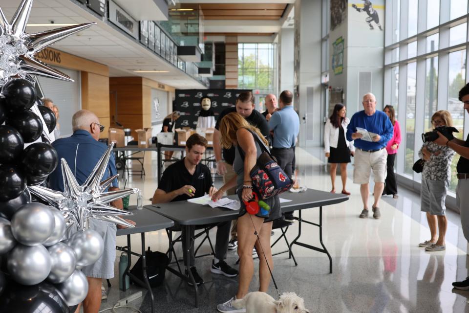 A Friar fan signs up for her PC license plates in the lobby of Schneider Arena on Friday.