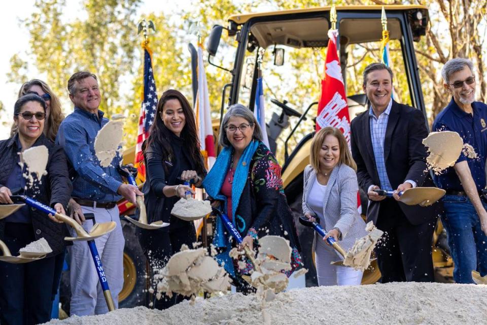 Representantes del Condado Miami-Dade, del Distrito de Gestión de Agua del Sur de la Florida y del Cuerpo de Ingenieros del Ejército lanzan arena durante la colocación de la primera piedra en el componente final del Proyecto de Humedales Costeros de la Bahía de Biscayne, cerca de Black Point Marina en Homestead el martes 21 de marzo de 2023.