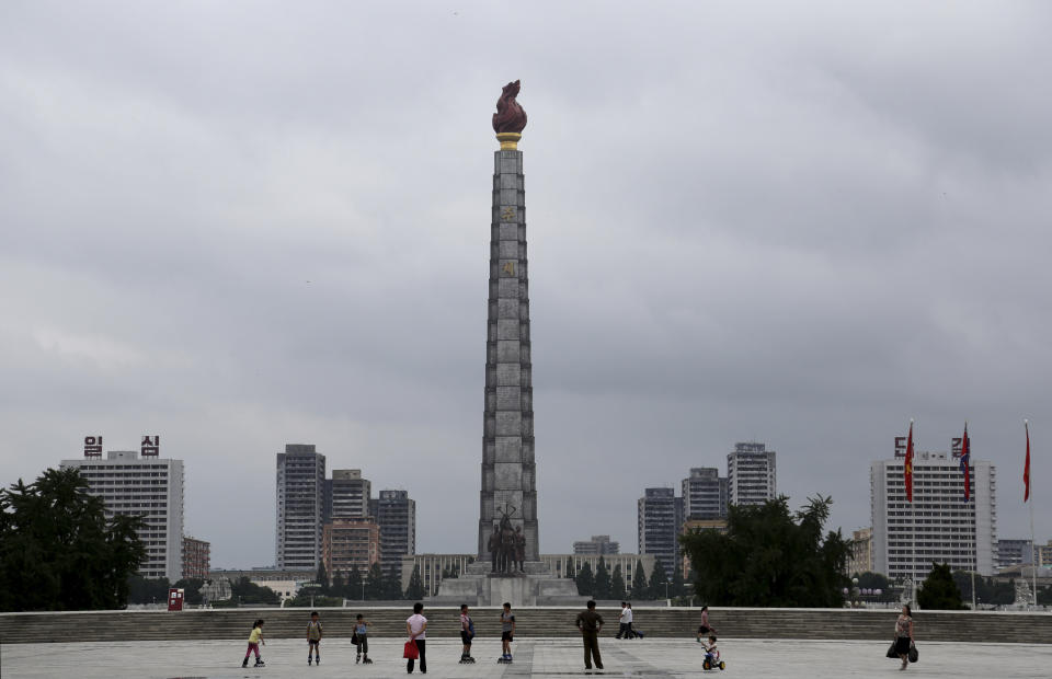 FILE - North Koreans are dwarfed against the Ju Che Tower from Kim Il Sung Square on July 21, 2013, downtown Pyongyang, North Korea. Russian tourists going on a ski trip will be the first international travelers to visit North Korea since the country's borders closed in 2020 amid the global pandemic lockdown, according to a report on the Russian state-run Tass news agency. (AP Photo/Wong Maye-E, File)
