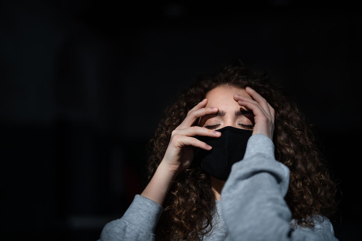 A portrait of depressed young woman indoors, covid-19 and mental health concept.