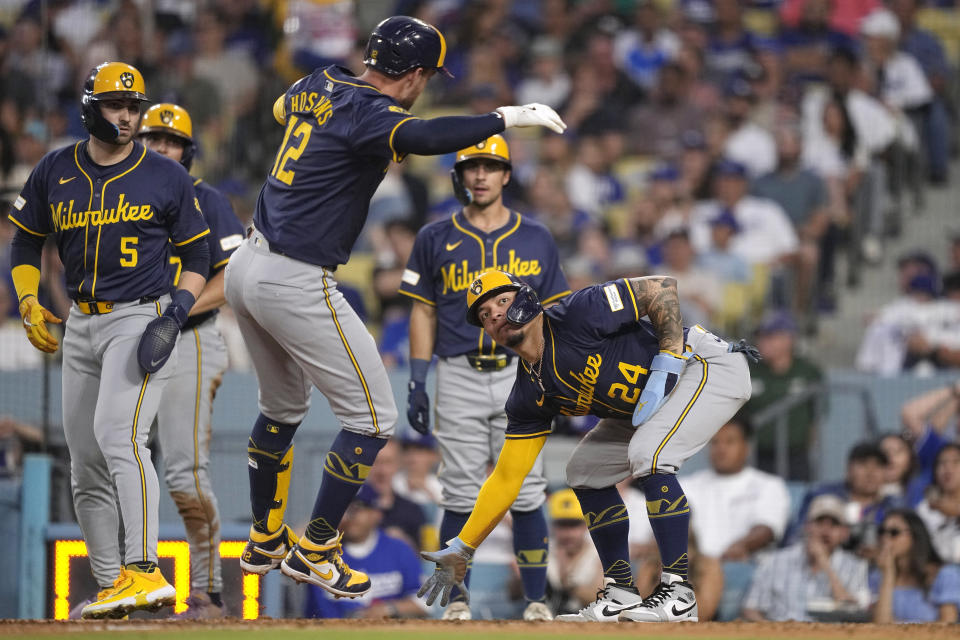 Milwaukee Brewers' Rhys Hoskins, center, is congratulated by William Contreras, right, Garrett Mitchell, left, Willy Adames, second from left, and Sal Frelick after hitting a grand slam during the fourth inning of a baseball game against the Los Angeles Dodgers Friday, July 5, 2024, in Los Angeles. (AP Photo/Mark J. Terrill)