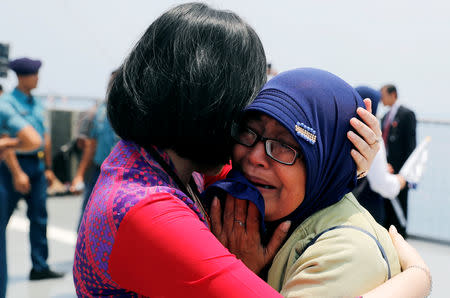 Families and colleagues of passengers and crew of Lion Air flight JT610 cry on the deck of Indonesia Navy ship KRI Banjarmasin as they visit the site of the crash to pay their tribute, at the north coast of Karawang, Indonesia, November 6, 2018. REUTERS/Beawiharta/Files