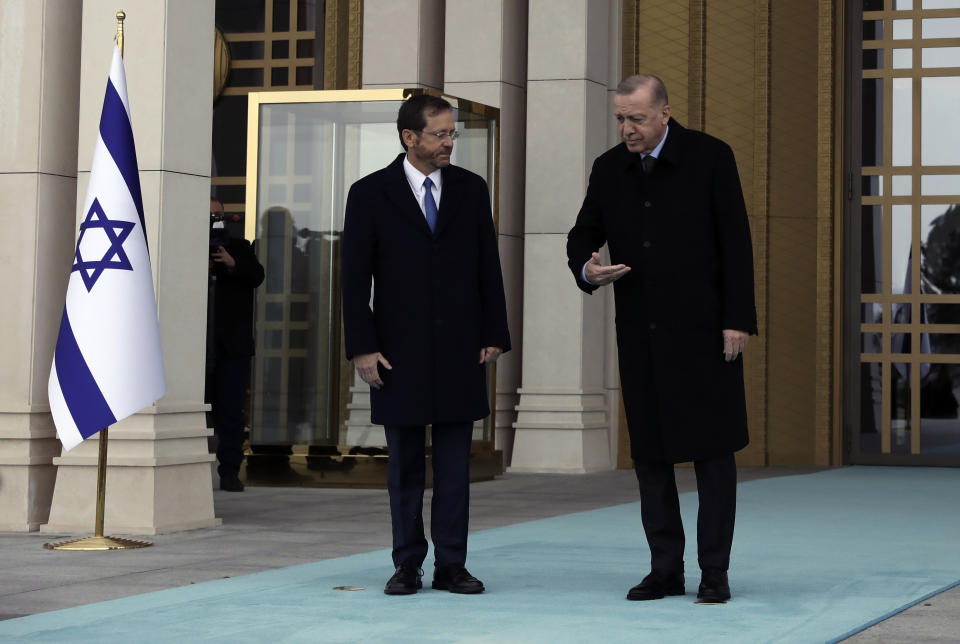 Turkish President Recep Tayyip Erdogan, right, shows the way to Israel's President Isaac Herzog pose during a welcome ceremony, in Ankara, Turkey, Wednesday, March 9, 2022. President Isaac Herzog is the first Israeli leader to visit Turkey since 2008. (AP Photo/Burhan Ozbilici)