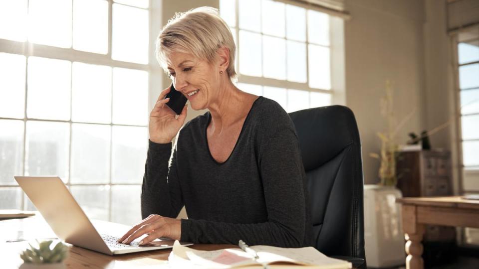 amazon package stolen: Shot of a businesswoman talking on her cellphone while using her laptop