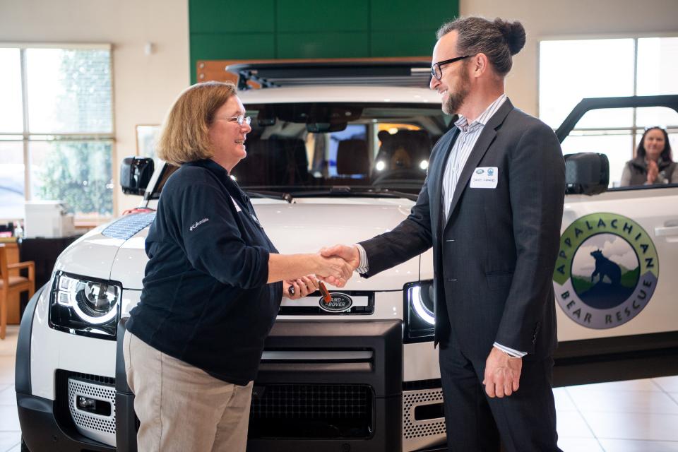 Appalachian Bear Rescue executive director Dana Dodd, left, shakes hands with Land Rover USA's James Crowley after receiving the keys to the Land Rover Defender 130 SUV awarded to Appalachian Bear Rescue as part of Land Rover USA's Defender Service Awards during an event at Land Rover Knoxville on Tuesday, Feb. 21, 2023. 