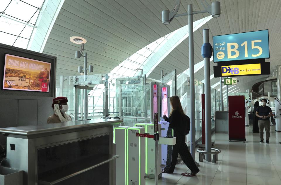 A woman enters the face and iris-recognition gate to board a plane, during a media tour at Dubai Airport, in the United Arab Emirates, Sunday, March 7, 2021. Dubai's airport, the world’s busiest for international travel, has introduced an iris-scanner that verifies one’s identity and eliminates the need for any human interaction when leaving the country. It’s the latest artificial intelligence program the UAE has launched amid the surging coronavirus pandemic. (AP Photo/Kamran Jebreili)