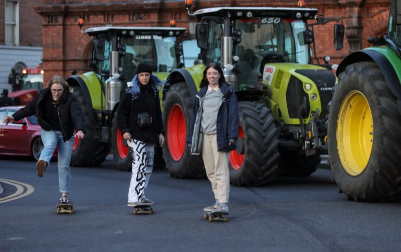 Skateboarders avoid the traffic jam caused by farmers' protest near Government Buildings in Dublin