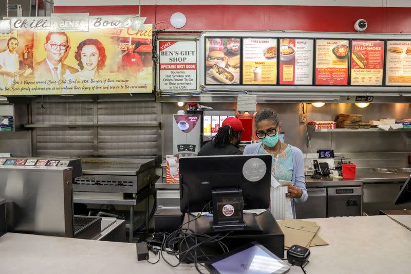 FILE PHOTO: Ali closes out the register at the end of service at Ben Chili Bowl as the restaurant navigates the coronavirus disease (COVID-19) outbreak in Washington