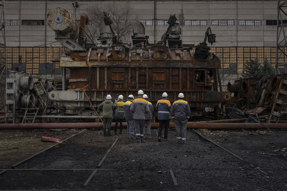 Varios trabajadores de una central eléctrica miran un enorme transformador de voltaje dañado después de un ataque ruso en el centro de Ucrania, el jueves 5 de enero de 2023. Cuando Ucrania estaba en paz, sus trabajadores del sector energético pasaban desapercibidos, pero la guerra los convirtió en héroes. Están demostrando ser la línea de defensa de Ucrania frente a los repetidos ataques rusos con misiles y drones contra la red energética, que provocan el sufrimiento que acompaña los apagones en pleno invierno. (AP Foto/Evgeniy Maloletka)