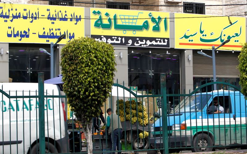 View shows a market for groceries with a Hezbollah slogan on it, in Beirut suburbs