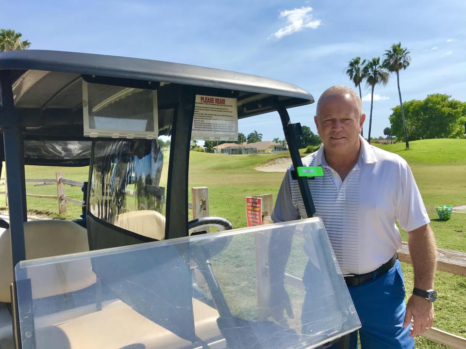 Brian Symonds, owner of Winston Trails Golf Club in Lake Worth, stands beside one of his carts.