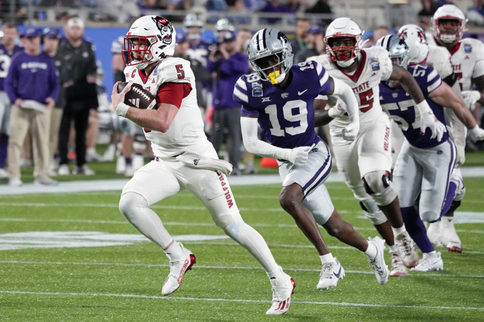 North Carolina State quarterback Brennan Armstrong (5) rushes past Kansas State safety VJ Payne (19) for a 31-yard touchdown run during the first half of the Pop-Tarts Bowl NCAA college football game, Thursday, Dec. 28, 2023, in Orlando, Fla. (AP Photo/John Raoux)