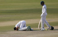 Pakistan's Fawad Alam, center, prostrates after scoring century while his teammate Faheem Ashraf watches during the second day of the first cricket test match between Pakistan and South Africa at the National Stadium, in Karachi, Pakistan, Wednesday, Jan. 27, 2021. (AP Photo/Anjum Naveed)