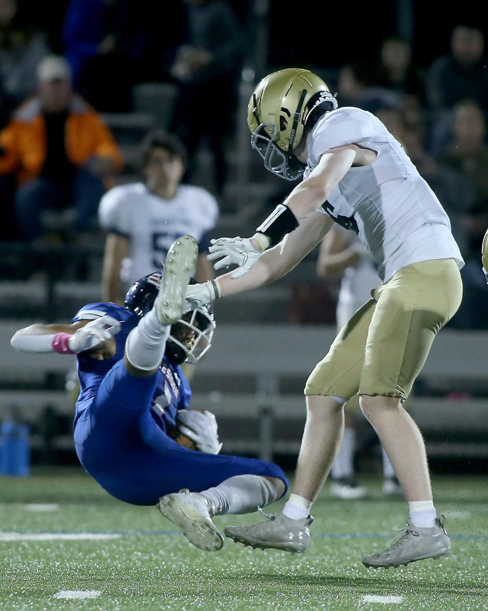 Quincy's Jacey Ham survives a massive hit by Hanover's John McDonald to make the fourth down catch and get the first down during second quarter action of their game against Hanover at Veterans Memorial Stadium in Quincy on Friday, Oct. 7, 2022.