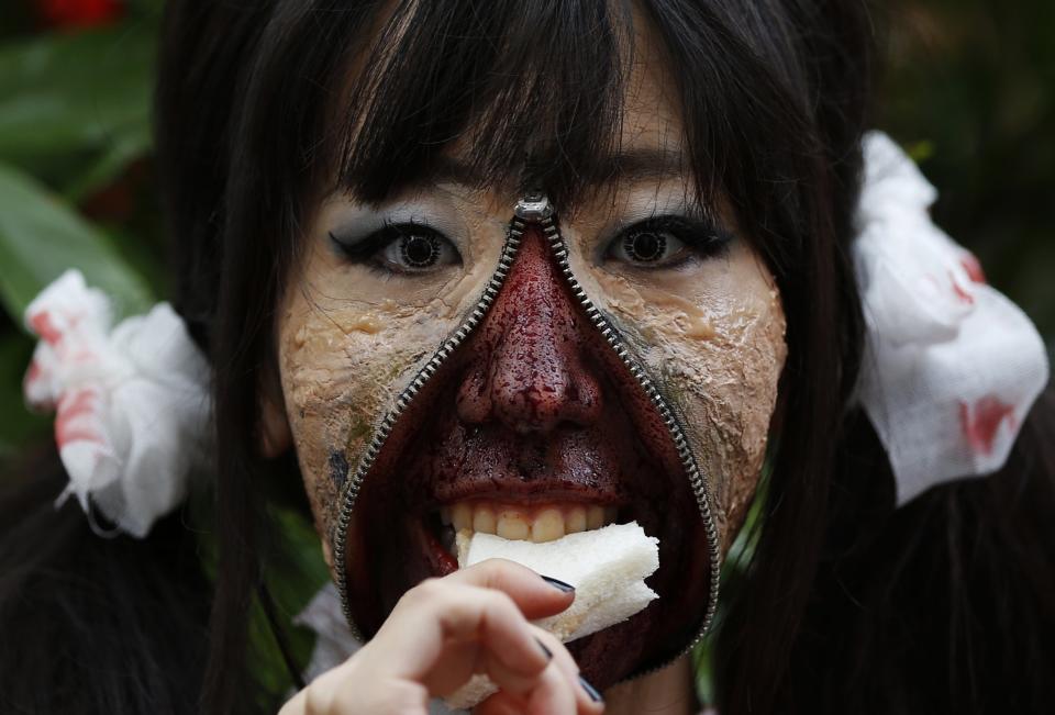 RNPS - REUTERS NEWS PICTURE SERVICE - PICTURES OF THE YEAR 2014 - ODDLY A participant in costume eats a sandwich after a Halloween parade in Kawasaki, south of Tokyo, in this October 26, 2014 file photo. REUTERS/Yuya Shino/Files (JAPAN - Tags: SOCIETY TPX IMAGES OF THE DAY)