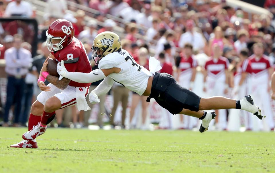 Oklahoma's Dillon Gabriel (8) is tackled by UCF's Kam Moore (30) in the first half of the college football game between the University of Oklahoma Sooners and the University of Central Florida Knights at Gaylord Family Oklahoma-Memorial Stadium in Norman, Okla., Saturday, Oct., 21, 2023.