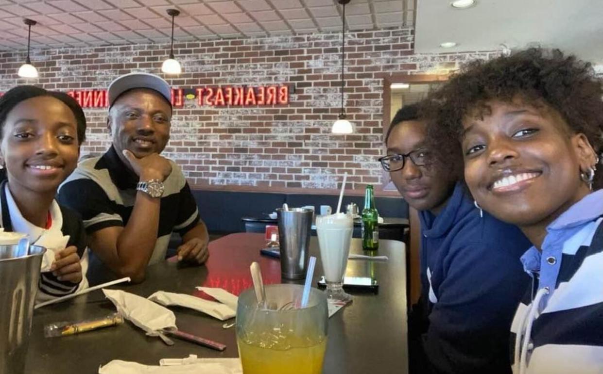 Norbert Munyarusisiro at a restaurant with three of his four children. From left to right, Greta Mutesi, Patient Mugisha and Grace Uwera. (Submitted by Norbert Munyarusisiro - image credit)