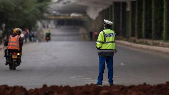 A police officer enforces a cordon on a section of motorway underneath the Nairobi expressway