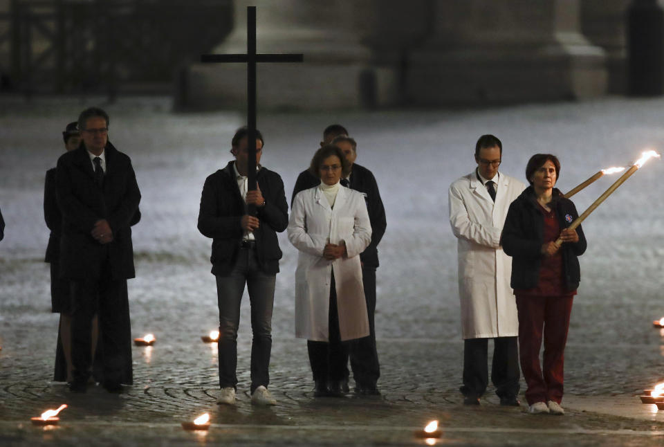 A man holds the cross during the Via Crucis – or Way of the Cross – ceremony in front of St. Peter's Basilica, empty of the faithful following Italy's ban on gatherings during a national lockdown to contain contagion, at the Vatican, Friday, April 10, 2020. (AP Photo/Alessandra Tarantino)