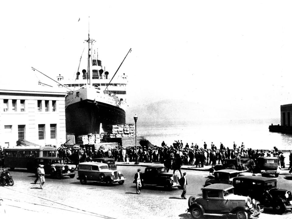 An estimated 1,000 striking longshoremen shout and sing as they parade in along the Embarcadero, San Francisco's waterfront, Ca., May 10, 1934. On May 9, International Labor Association (ILA) leaders called a strike of all dockworkers on the West Coast, seeking highter wages and a shorter working week. The dockworkers were joined a few days later by seamen and teamsters.