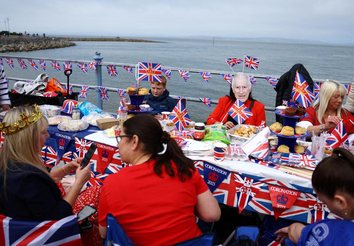 Afternoon tea is shared between neighbours during celebrations on the prom in Morecambe (REUTERS)