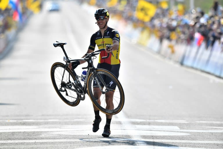 Belgian cyclist Philippe Gilbert carries his bike as he crosses the finish line to win the Tour of Flanders, a 260km race from Antwerp to Oudenaarde, on April 2, 2017