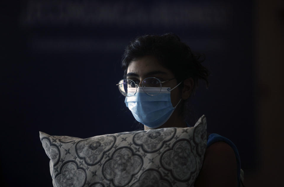 Una pasajera con una máscara facial para protegerse contra el nuevo coronavirus espera para abordar un vuelo humanitario a los Estados Unidos en el Aeropuerto Internacional de Tocumen en la Ciudad de Panamá, el viernes 8 de mayo de 2020. (Foto AP/Arnulfo Franco)