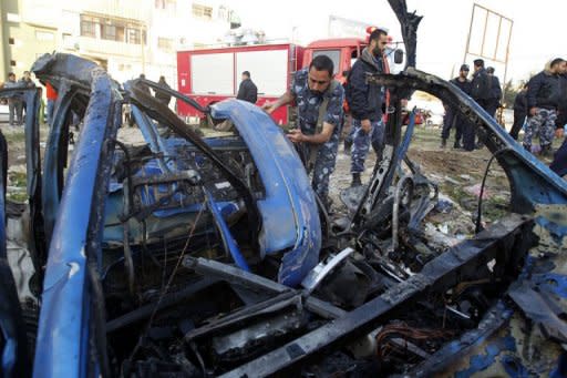 A Hamas policeman inspects the remains of a vehicle after it was targeted by an Israeli air strike that killed the head of the Popular Resistance Committees militant group in Gaza City