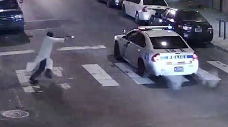 A still image from surveillance video shows a gunman (L) approaching a Philadelphia Police vehicle in which Officer Jesse Hartnett was shot shortly before midnight January 7, 2016 in Philadelphia, Pennsylvania this Philadelphia Police Department image released on January 8, 2016. REUTERS/Philadelphia Police Department/Handout