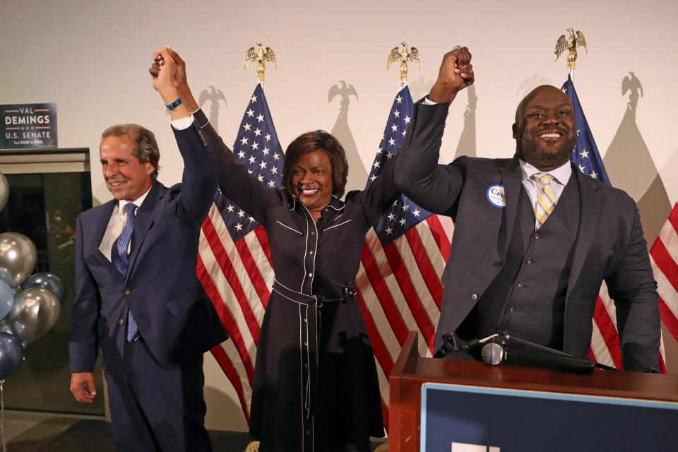 Chair of the Florida Democratic Party Manny Diaz, U.S. Rep. Val Demings, and Broward Democratic Party Chair Rick Hoye raise their hands during a Democratic unity rally on Thursday, Aug. 25, 2022, in Tamarac, Fla. (John McCall/South Florida Sun-Sentinel via AP)