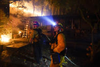 Firefighters monitor the advance of the CZU August Lightning Complex Fire in the backyard of a home Friday, Aug. 21, 2020, in Boulder Creek, Calif. Firefighters trying to contain the massive wildfires in Oregon, California and Washington state are constantly on the verge of exhaustion as they try to save suburban houses, including some in their own neighborhoods. (AP Photo/Marcio Jose Sanchez)