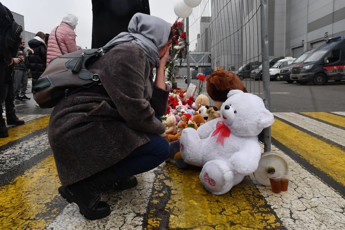 A woman mourns at a makeshift memorial in front of Crocus City Hall (AFP via Getty Images)