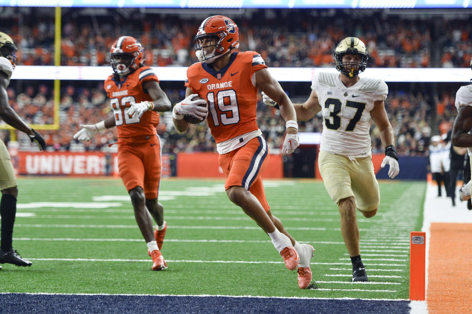 FILE - Syracuse wide receiver Oronde Gadsden II, center, scores a touchdown against Purdue during the second half of an NCAA college football game in Syracuse, N.Y., Saturday, Sept. 17, 2022. Syracuse opens their season at home against Colgate on Sept. 2. (AP Photo/Adrian Kraus, File)