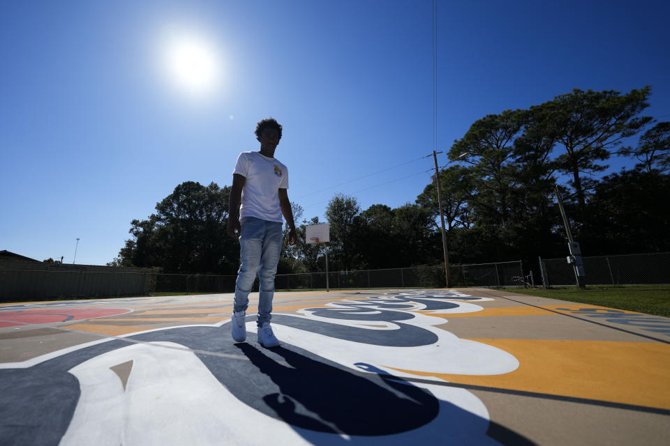 Bryant West poses for a portrait on a basketball court built by NBA star Devin Booker, who went to high school here, in Moss Point, Miss., Friday, Oct. 20, 2023. Girls consistently are outperforming boys, graduating at higher rates at public high schools around the country. Students, educators and researchers say there are several reasons why boys are falling short.(AP Photo/Gerald Herbert)