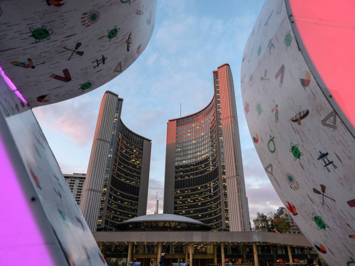 Toronto's city hall building is seen through letters of the TORONTO sign in Nathan Phillips Square. (Evan Mitsui/CBC - image credit)