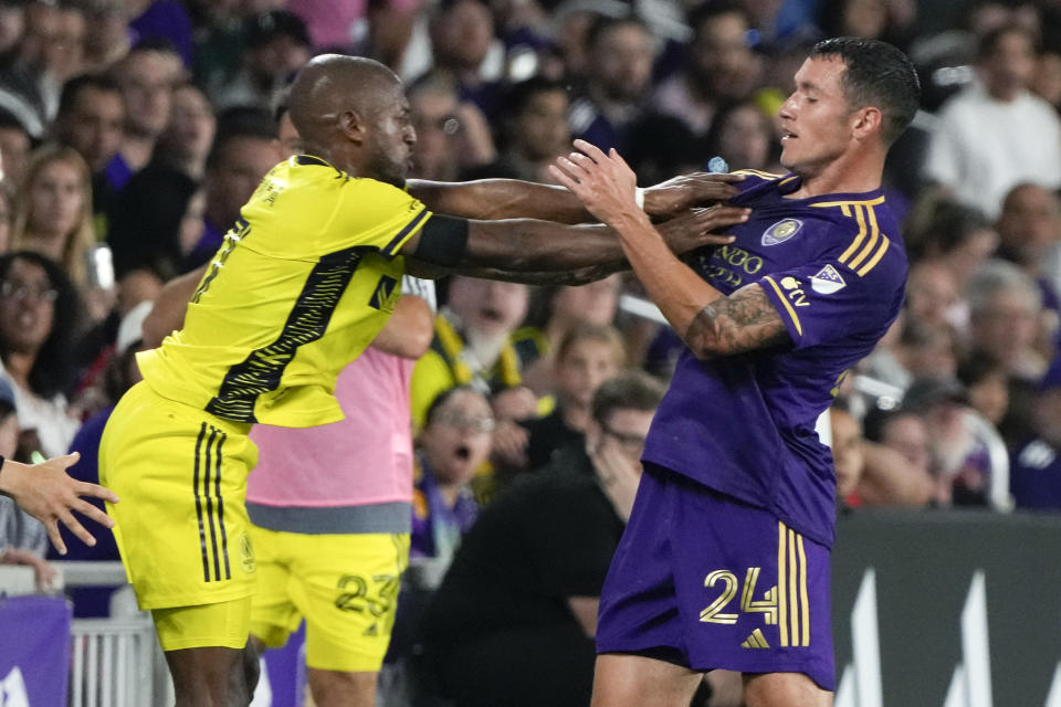 Nashville SC's Fafa Picault, left, and Orlando City's Kyle Smith (24) get in a shoving match during the second half of an MLS soccer match, Saturday, April 1, 2023, in Orlando, Fla. Both players were issued yellow cards. (AP Photo/John Raoux)