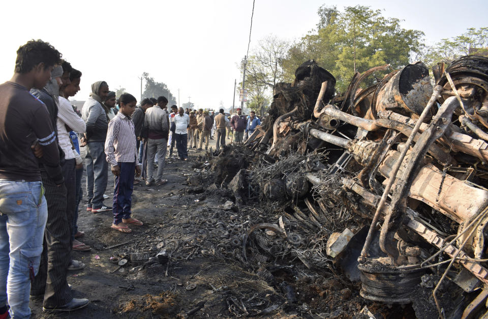 People look at what remains of a bus that caught fire after ramming into a truck in Kannauj, in the northern Indian state of Uttar Pradesh, Saturday, Jan. 11, 2020. At least 20 people died when in the accident, police said. Another 21 people were taken to a hospital, some of them in critical condition, following the crash late Friday, said senior police officer Mohit Aggarwal. (AP Photo)