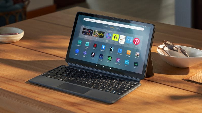 The Amazon Fire Max 11 tablet in landscape mode with its keyboard case attached sitting on a wooden table.