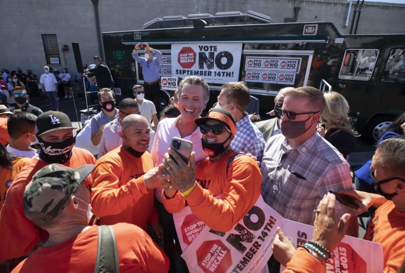 SUN VALLEY, CA - SEPTEMBER 12: Gov. Gavin Newsom takes a picture with Joseph Martinez, left, and Christopher Gray following his campaign rally in Sun Valley urging those gathered to vote no on the recall. Photographed at Chef Robert Catering on Sunday, Sept. 12, 2021 in Sun Valley, CA. (Myung J. Chun / Los Angeles Times)