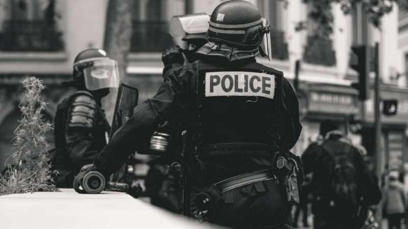 Black and white photo of police in riot gear