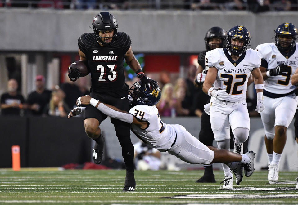 Murray State defensive back Kanyon Walker (34) attempts to tackle Louisville running back Isaac Guerendo (23) during the first half of an NCAA college football game in Louisville, Ky., Thursday, Sept. 7, 2023. (AP Photo/Timothy D. Easley)