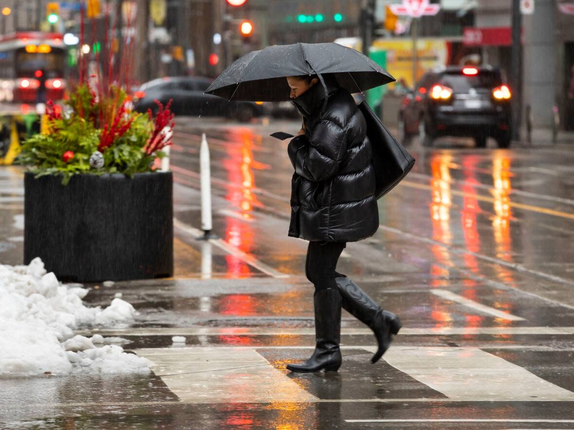 A person walking through the rainy weather on December 15, 2022. Environment Canada has issued a special weather statement for Toronto calling for possible heavy rain and strong winds Thursday. (Michael Wilson/CBC - image credit)