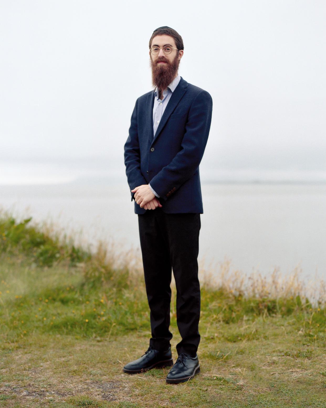 Man standing in front of Icelandic landscape.