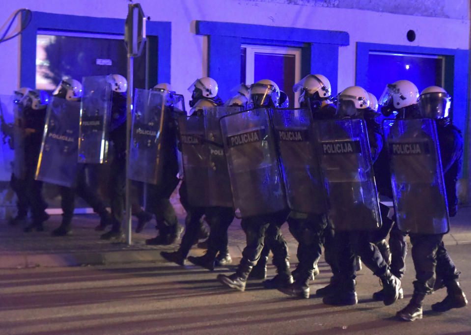 Montenegrin police officers block the street during a protest in Niksic, Montenegro, Wednesday, May 13, 2020. Montenegrin police used tear gas to disperse protests demanding the release of eight Serbian Orthodox Church priests who were detained for organizing a religious procession despite a ban on gatherings because of the coronavirus. (AP Photo/Risto Bozovic)