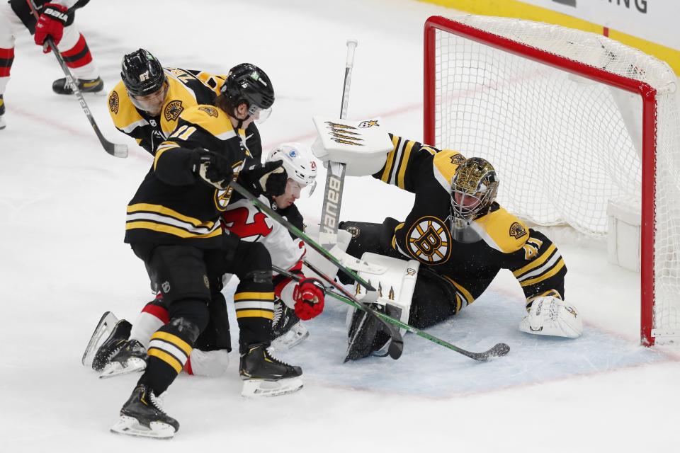 New Jersey Devils' Ty Smith (24) collides with Boston Bruins' Jaroslav Halak (41) during the second period of an NHL hockey game, Sunday, March 28, 2021, in Boston. (AP Photo/Michael Dwyer)