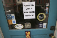 FILE - In this March 25, 2020 file photo, a closed sign hangs in the window of a shop in Portsmouth, N.H., due to caronavirus concerns. The Federal Reserve is taking additional steps to provide up to $2.3 trillion in loans to suport American households and businesses as well as local governments as they deal with the coronavirus. The Fed said Thursday, April 9, among the actions it is taking is the activation of a Main Street Lending Program that was authorized by the $2.3 trillion economic relief bill pass by Congress last month. (AP Photo/Charles Krupa, File)