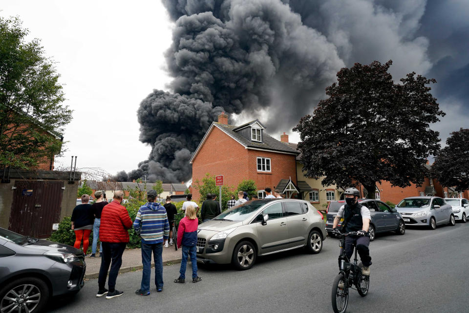 <p>Local residents watch a large fire at an industrial premises in in Juno Drive, Leamington Spa, Warwickshire. Picture date: Thursday August 27, 2021.</p>
