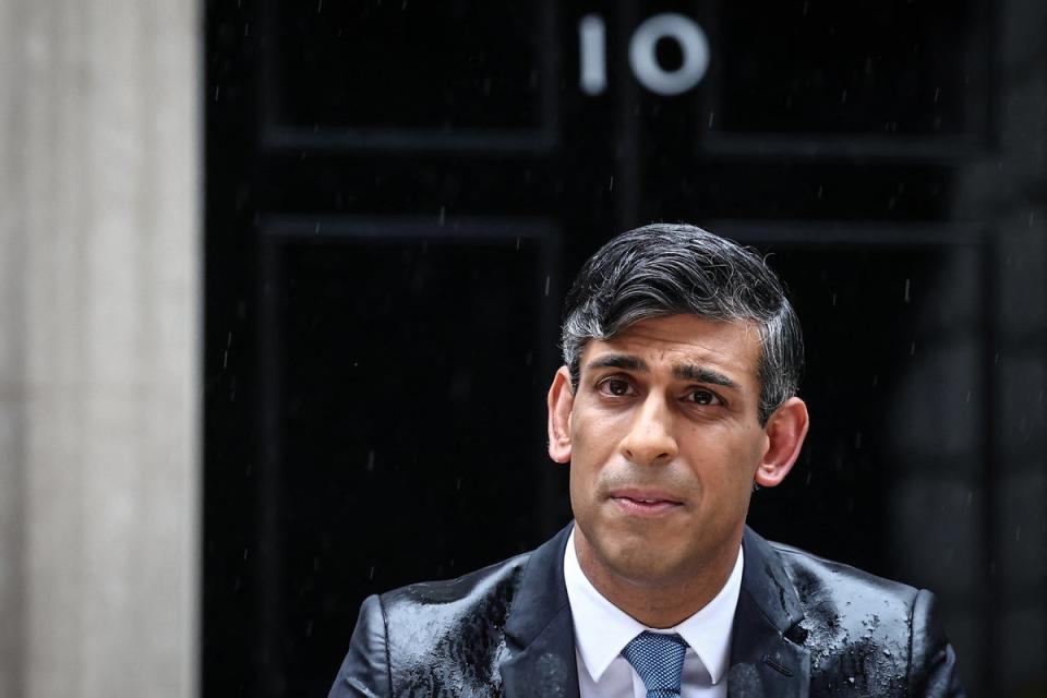 Rishi Sunak, soaked in rain, pauses as he delivers a speech to announce the election date (Getty)