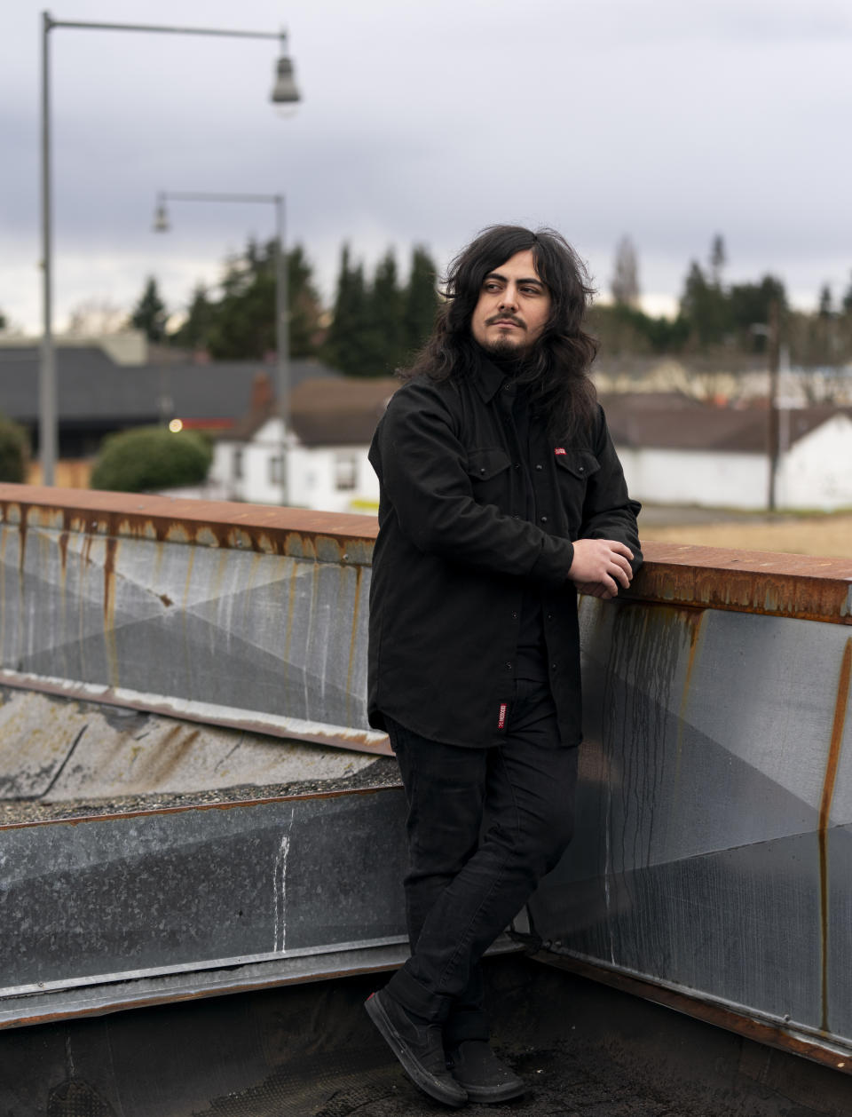 CORRECTS TO TWO SEMESTERS, NOT ONE - Santos Enrique Camara, 27, who dropped out of Shoreline Community College at age 19 in 2015 after completing two semesters studying audio engineering, poses for a portrait outside his home Friday, March 24, 2023, in Marysville, Wash. Two-year community colleges have the worst completion rates of any kind of university or college. Like Camara, nearly half of students drop out, within a year, of the community college where they started. Only slightly more than 40% finish within six years. (AP Photo/Lindsey Wasson)